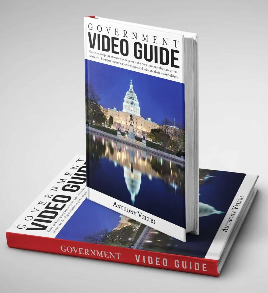 Two copies of a book titled "Government Video Guide" by Anthony Veltri are shown, one standing upright and the other lying flat. The cover features a photo of the U.S. Capitol building reflected in water at night.