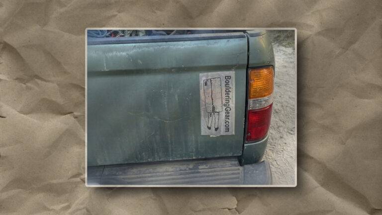 This image illustrates a faded green truck with a peeling gear sticker, suggesting prolonged outdoor use on rugged terrain.