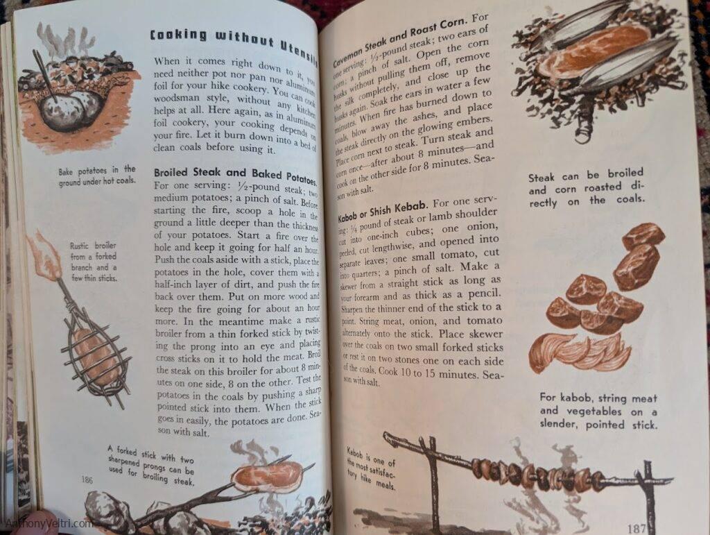 An open book shows illustrated instructions for cooking outdoors without utensils. Sketches depict potatoes, steak, corn, and shish kebabs roasting directly on coals or skewered over a fire, with descriptive text and rustic cooking methods on both pages.