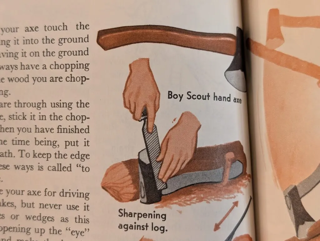An illustration shows a person sharpening a Boy Scout hand axe by filing its blade against a log. One hand holds the axe handle on the log, while the other hand moves a file across the axe blade. The image is labeled for clarity.